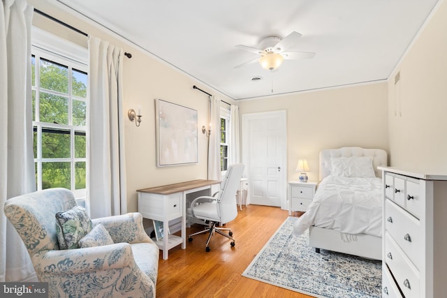 bedroom featuring ceiling fan, light hardwood / wood-style floors, and ornamental molding