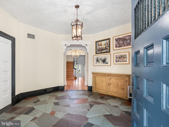 foyer featuring a chandelier and a textured ceiling