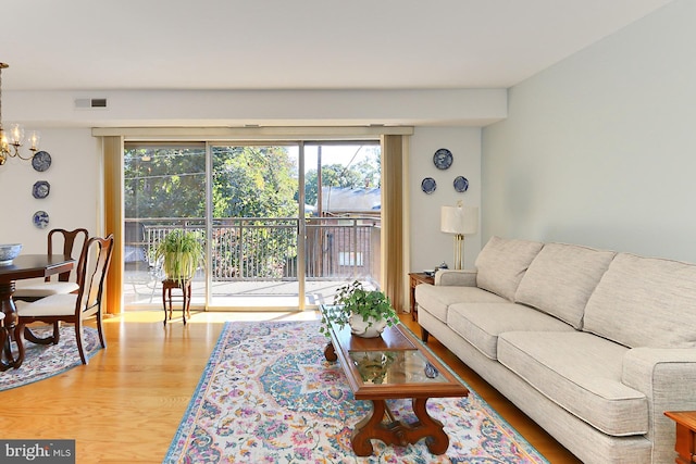 living room featuring a notable chandelier and light hardwood / wood-style flooring