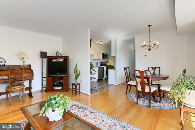 living room featuring light wood-type flooring and a notable chandelier