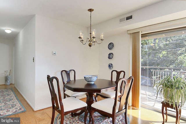 dining room featuring light wood-type flooring and a notable chandelier