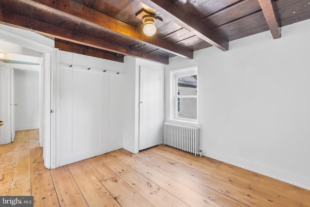 interior space with beamed ceiling, light hardwood / wood-style flooring, wooden ceiling, and radiator