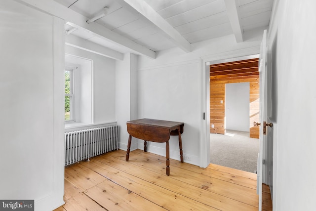 hall featuring radiator, beamed ceiling, and light hardwood / wood-style flooring