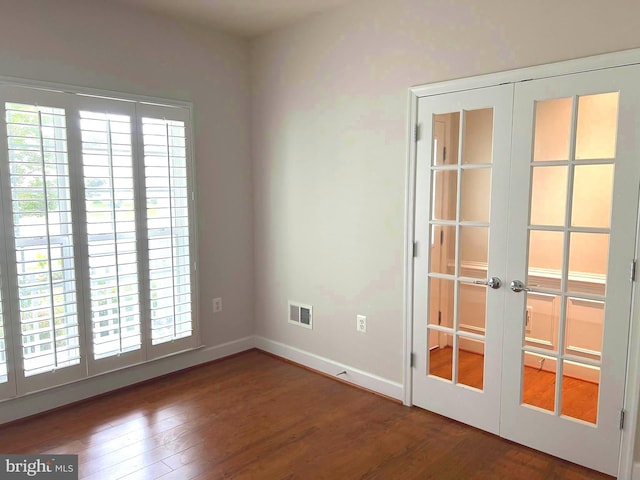 unfurnished room featuring french doors and dark hardwood / wood-style flooring