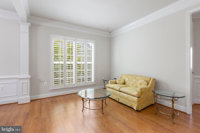 sitting room featuring ornamental molding, hardwood / wood-style flooring, and decorative columns