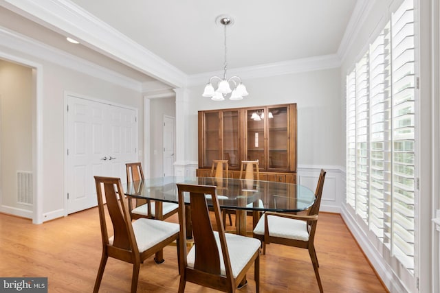 dining area with an inviting chandelier, crown molding, light hardwood / wood-style floors, and a wealth of natural light