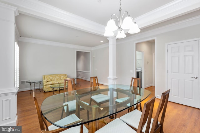 dining area with ornate columns, a notable chandelier, ornamental molding, and light hardwood / wood-style floors