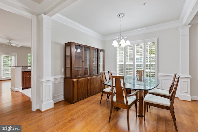 dining area featuring ceiling fan with notable chandelier, decorative columns, ornamental molding, and light hardwood / wood-style flooring