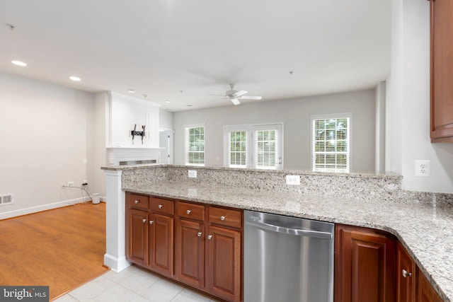 kitchen with light stone counters, ceiling fan, stainless steel dishwasher, and light hardwood / wood-style flooring