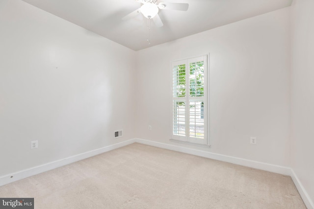 spare room featuring ceiling fan and light carpet