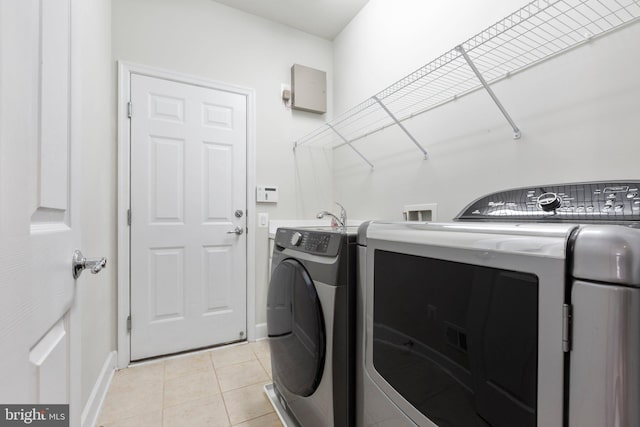 washroom featuring separate washer and dryer and light tile patterned floors