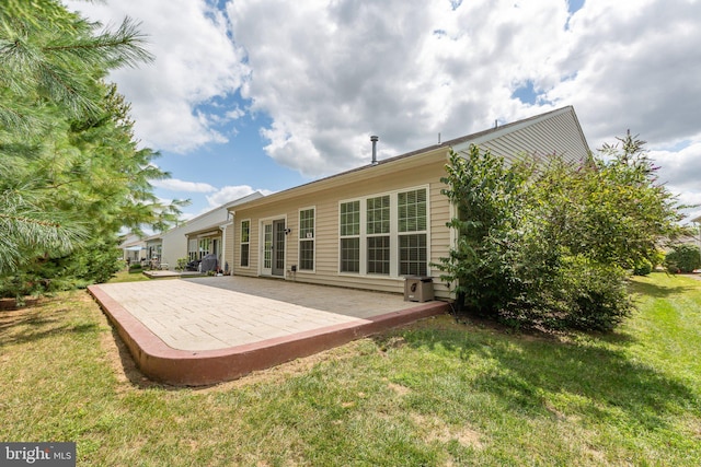 rear view of house featuring a patio area and a lawn