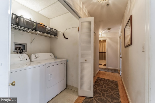 clothes washing area with washer and dryer and light hardwood / wood-style flooring