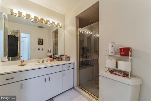 bathroom with toilet, vanity, and a shower with shower door