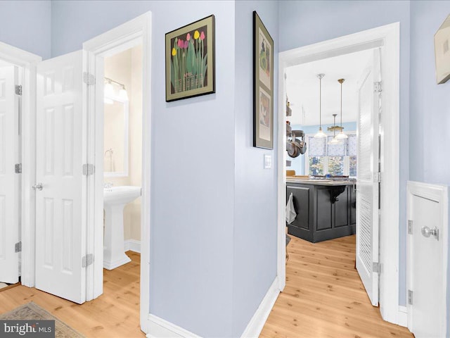 corridor featuring sink and hardwood / wood-style flooring