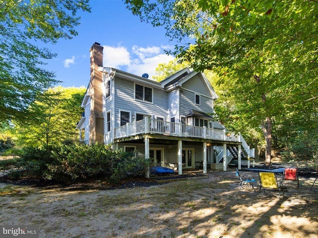 rear view of house featuring a wooden deck