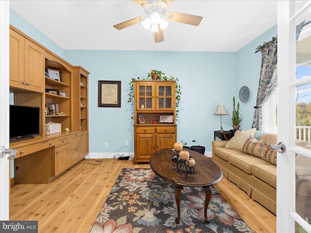 living room with light hardwood / wood-style flooring and ceiling fan