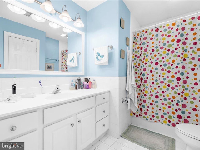 bathroom featuring vanity, tile patterned floors, toilet, and tile walls