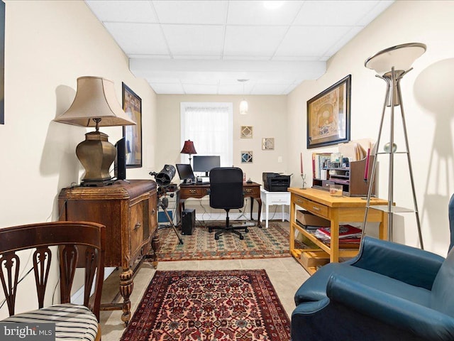 office space featuring a paneled ceiling and light tile patterned flooring