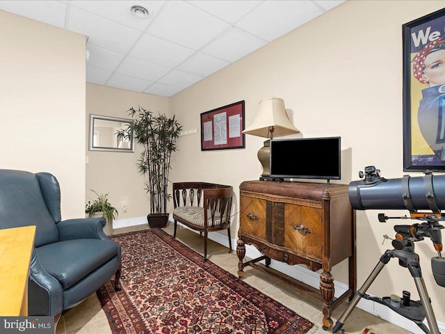 sitting room featuring light tile patterned floors and a drop ceiling