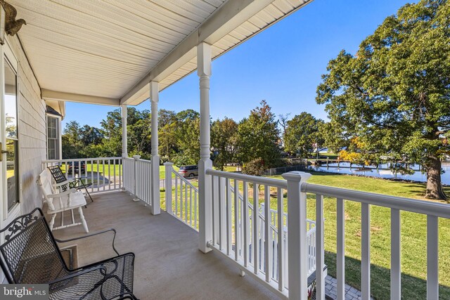 balcony featuring a water view and covered porch