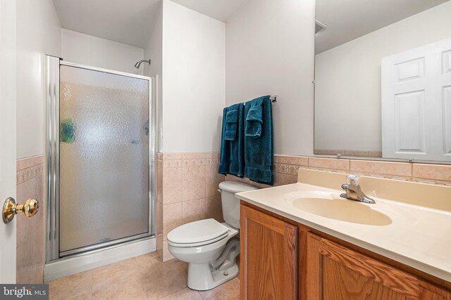 bathroom featuring an enclosed shower, toilet, tile walls, vanity, and tile patterned flooring