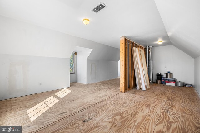 additional living space with vaulted ceiling and light hardwood / wood-style floors