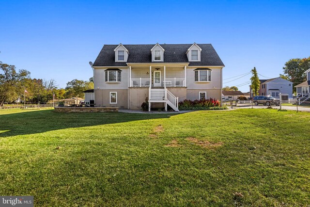 rear view of property with a porch and a lawn