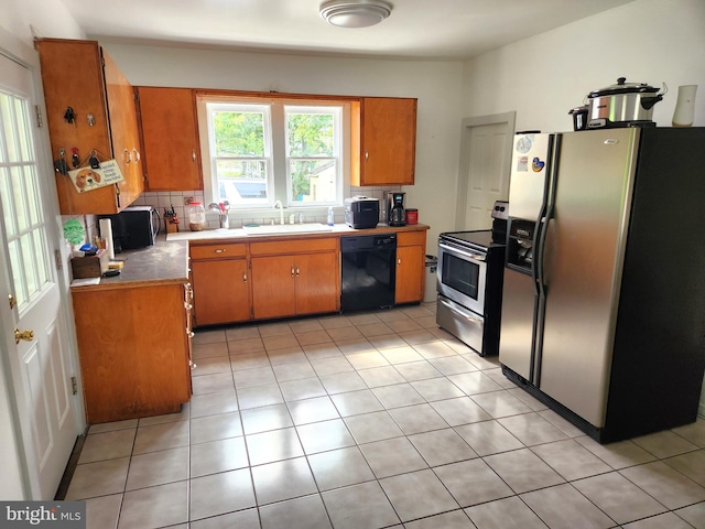 kitchen featuring light tile patterned floors, appliances with stainless steel finishes, sink, and decorative backsplash