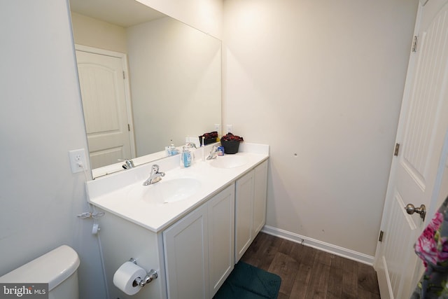 bathroom with vanity, toilet, and hardwood / wood-style flooring