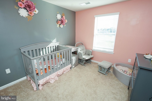 bedroom featuring a nursery area and carpet flooring