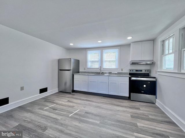 kitchen featuring a sink, stainless steel appliances, baseboards, under cabinet range hood, and recessed lighting