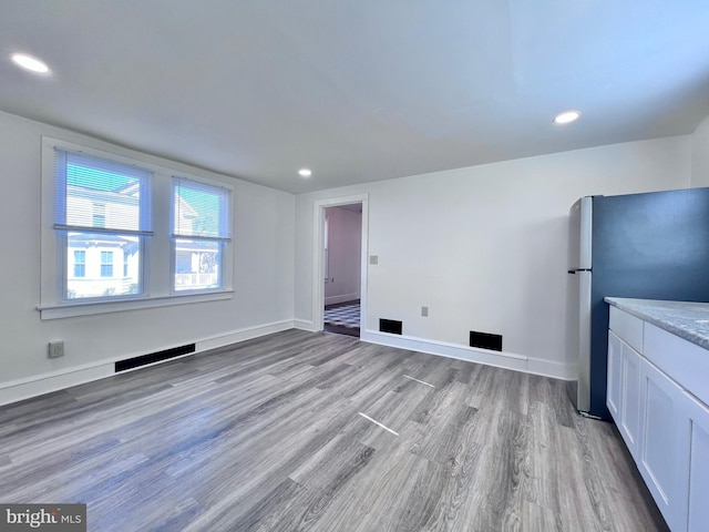 interior space featuring baseboards, visible vents, and light wood-style flooring