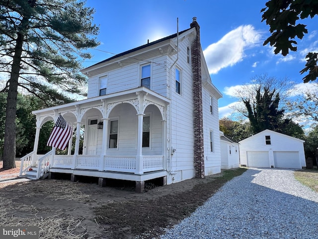 italianate-style house featuring a garage, an outbuilding, and a porch