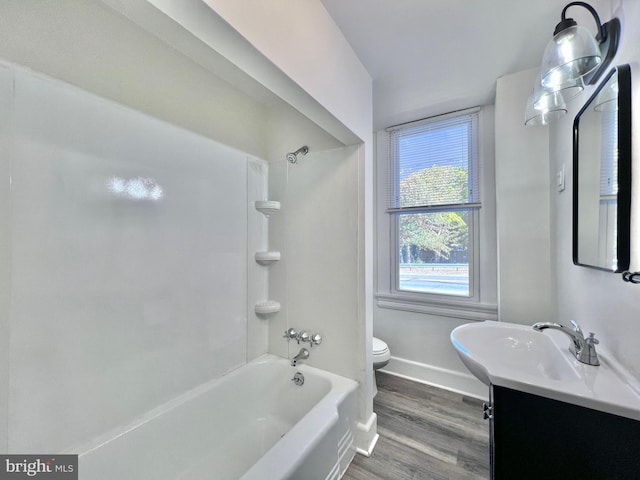 full bathroom with toilet, bathtub / shower combination, baseboards, wood finished floors, and vanity