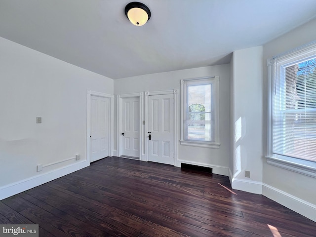 entryway featuring baseboards, dark wood-style floors, and a wealth of natural light