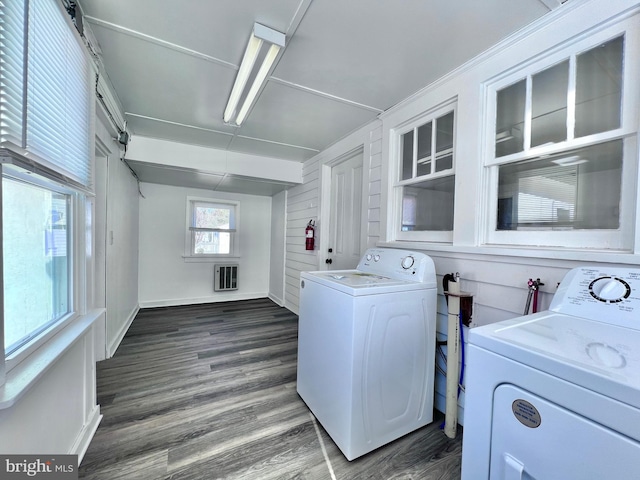 laundry area featuring heating unit, laundry area, washing machine and dryer, baseboards, and dark wood-style flooring
