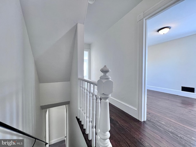 staircase featuring wood finished floors and baseboards