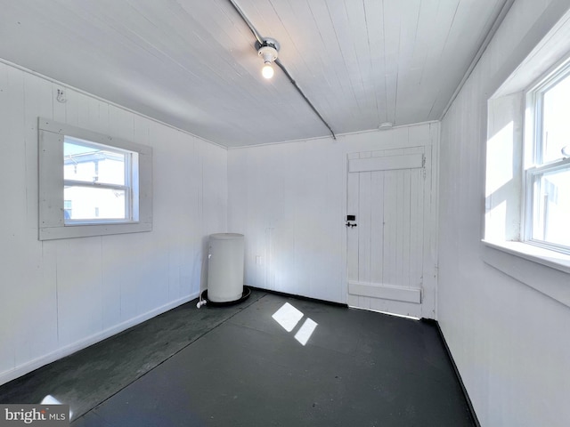 empty room featuring concrete flooring and wood ceiling
