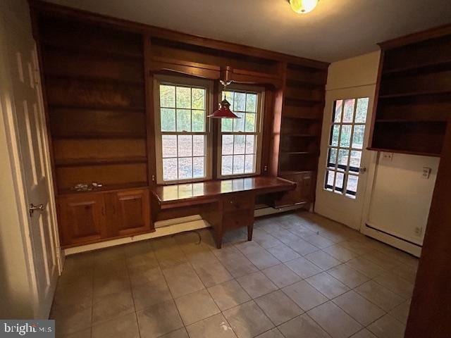 unfurnished dining area featuring plenty of natural light and a baseboard heating unit