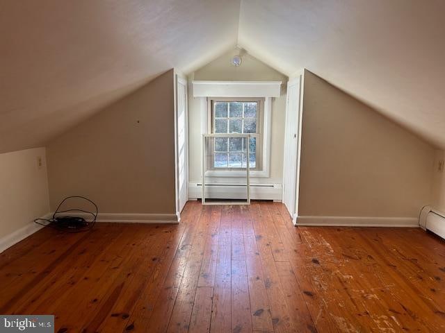 bonus room featuring vaulted ceiling, hardwood / wood-style flooring, and a baseboard radiator