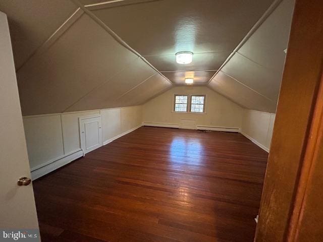 bonus room featuring dark wood-type flooring, a baseboard radiator, and lofted ceiling