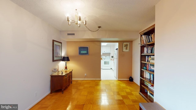 interior space featuring a chandelier and a textured ceiling