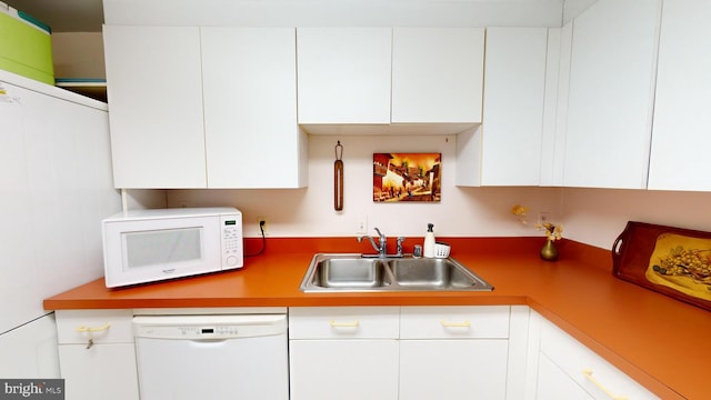 kitchen with white cabinets, white appliances, and sink