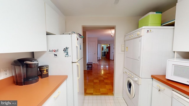 laundry room featuring stacked washer / drying machine