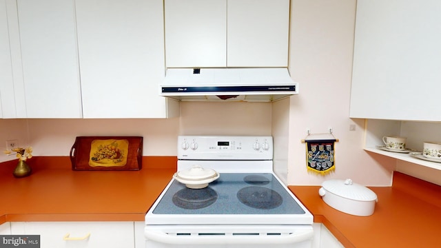 kitchen featuring white cabinets and white range oven