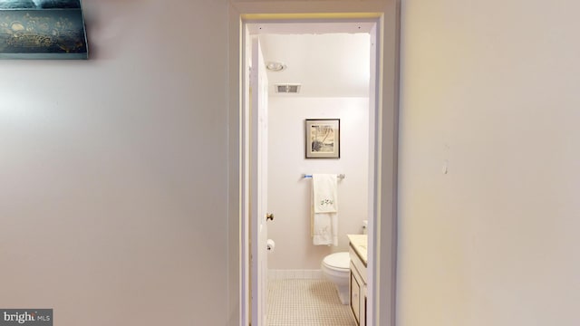 bathroom featuring tile patterned flooring, vanity, and toilet