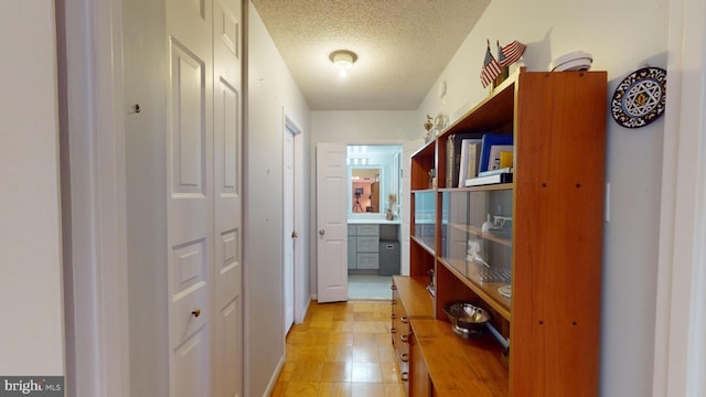 hall featuring a textured ceiling