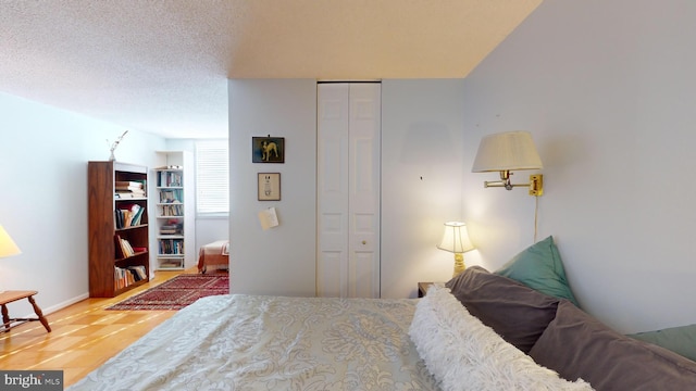 bedroom featuring a closet, hardwood / wood-style floors, and a textured ceiling