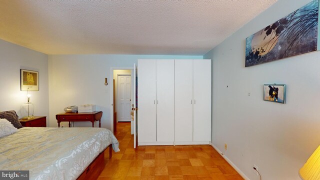 bedroom featuring a textured ceiling and a closet